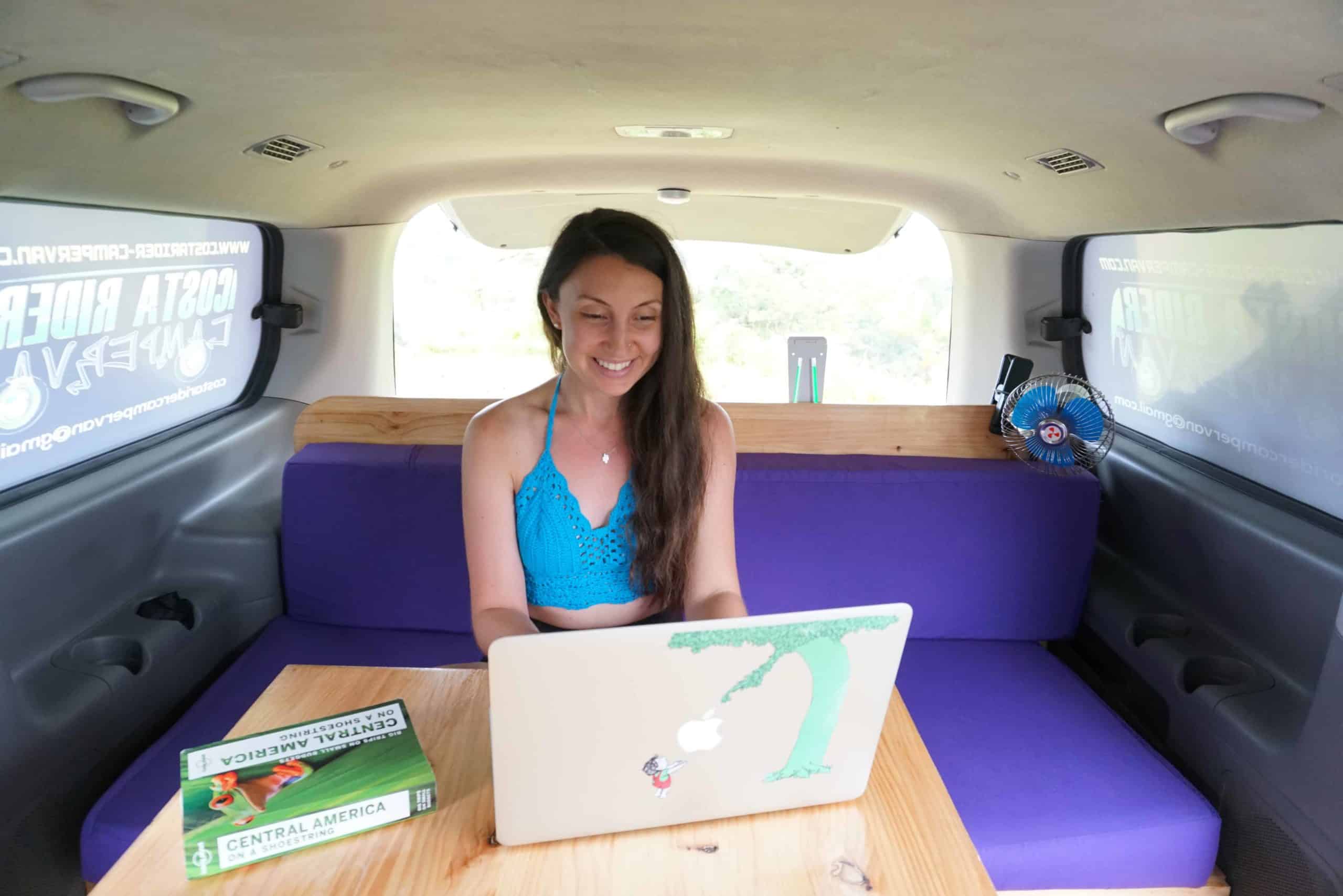 girl on laptop in camper van